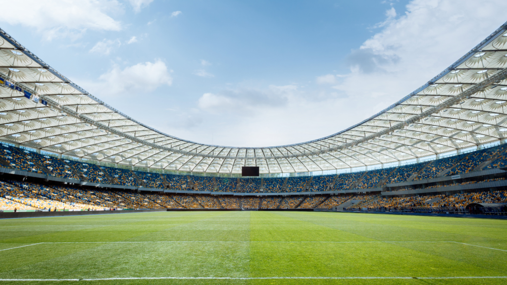 Interior de un estadio de fútbol con césped y gradas