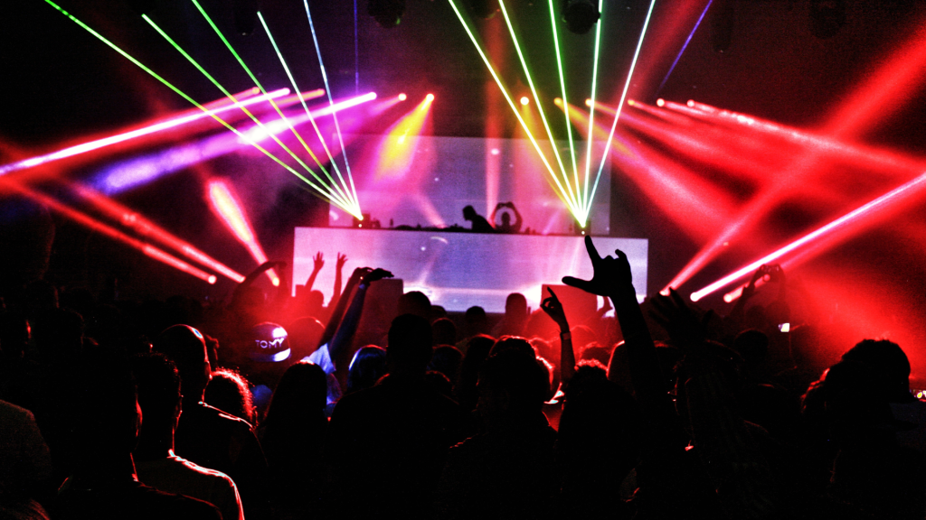 Crowd dancing under laser lights at a nightclub in Madrid