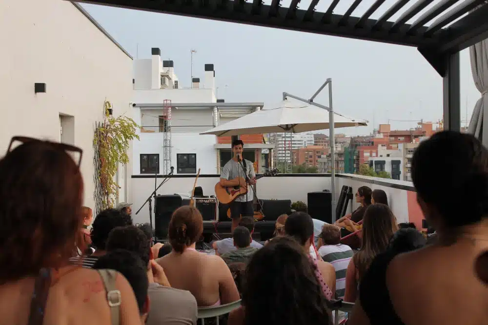 Solo musician performing at an acoustic rooftop session at an Urban Campus residence