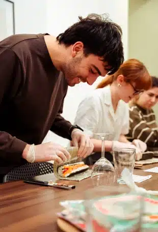 Résidents préparant des sushis ensemble lors d'un atelier cuisine
