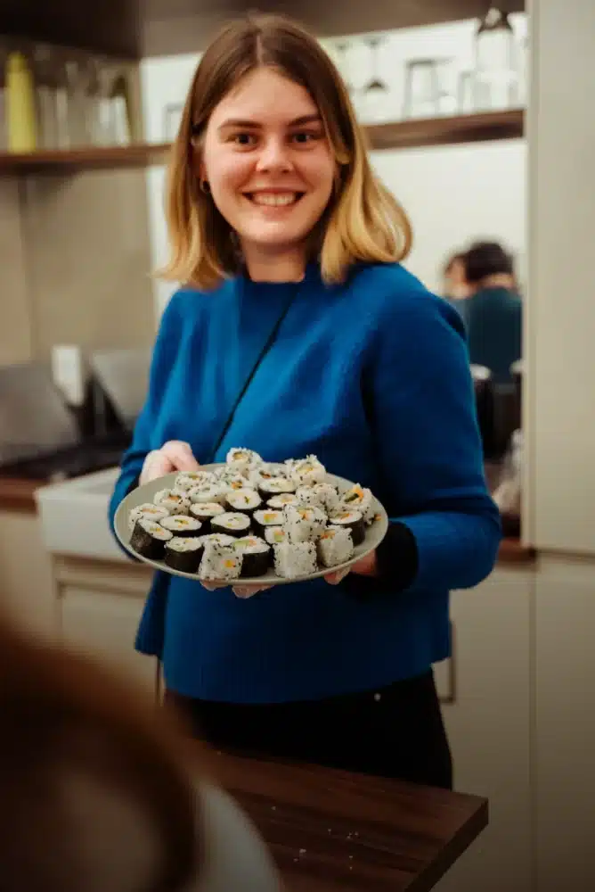 Urban Campus resident showing her homemade sushi rolls during a cooking workshop