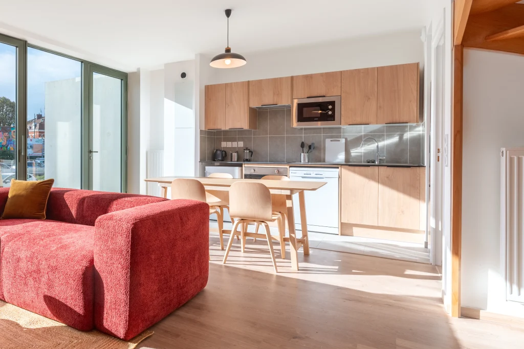 Living room and kitchen with outside view in an apartment at Urban Campus La Maillerie Coliving in Lille