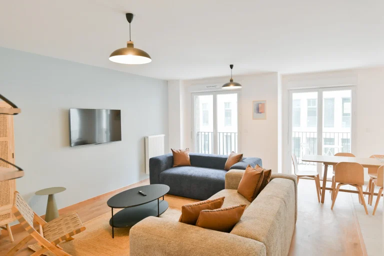 Living room with TV and dining area in an apartment at Urban Campus La Maillerie Coliving in Lille