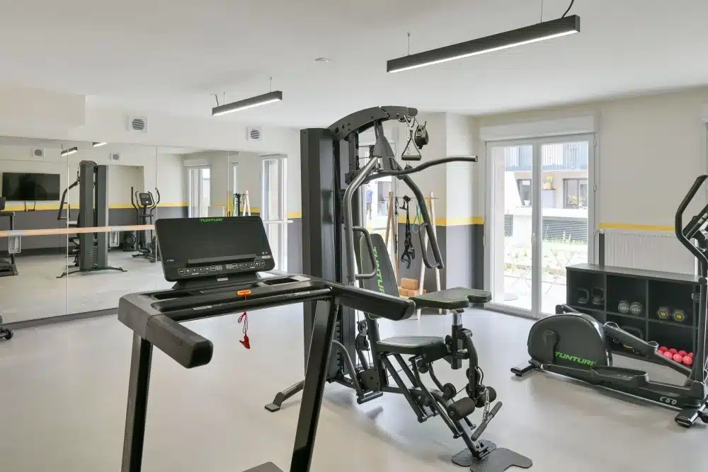 Gym at Urban Campus La Maillerie Coliving in Lille with cardio equipment and weights