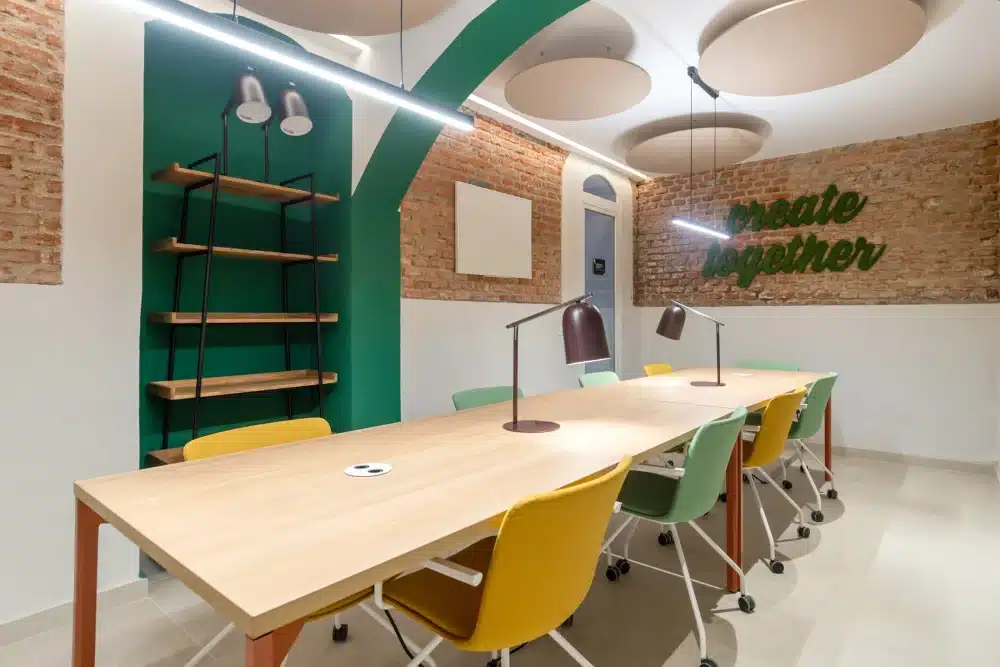Coworking space at Urban Campus Atocha Madrid, shared desks and green wall accent