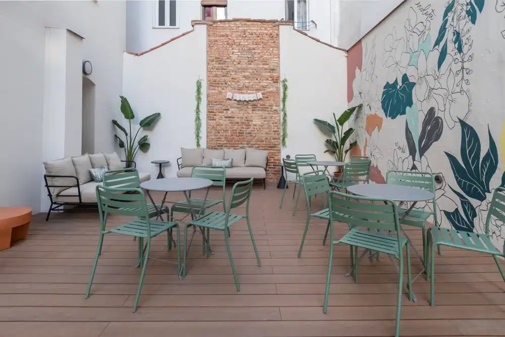 Outdoor patio at Urban Campus Atocha Madrid, lounge seating and mural wall