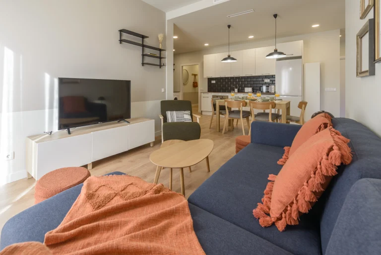 Living room with TV and open kitchen at Urban Campus Avenida América Coliving in Madrid