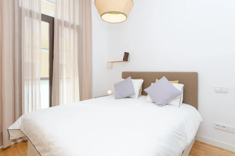 Bedroom at Urban Campus Malasaña Coliving in Madrid, bed with pillows near a large window