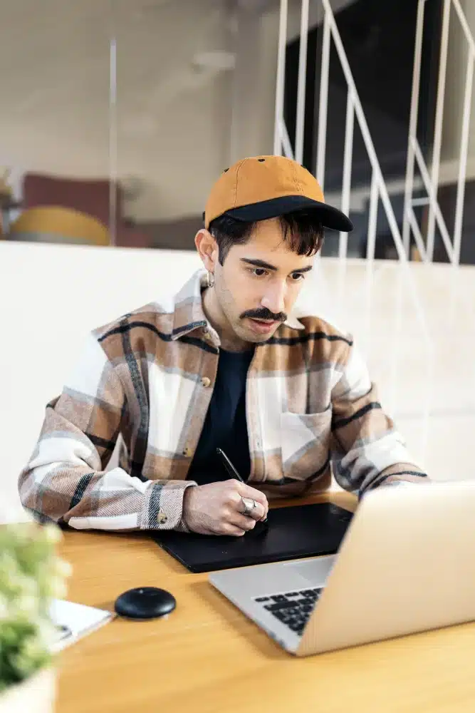 Residente satisfecho trabajando con una tableta gráfica en un espacio coworking de Urban Campus