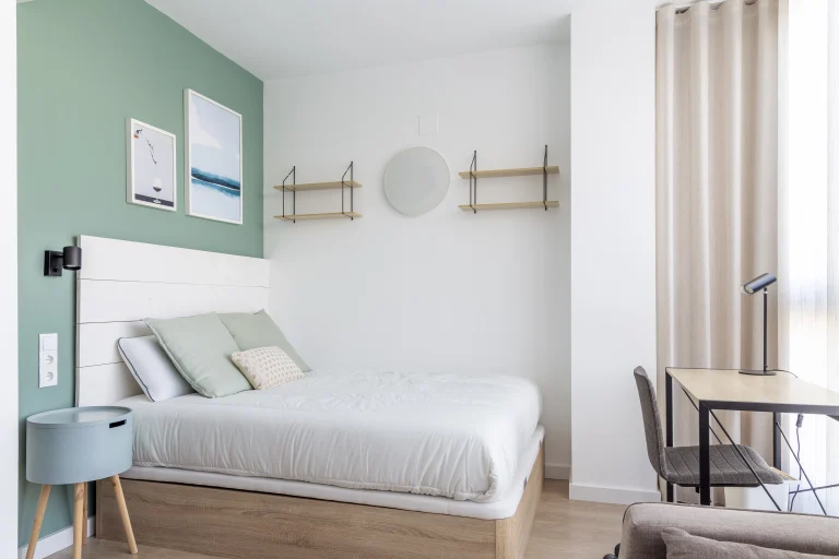 Bedroom at Urban Campus Ayora Coliving in Valencia, with green wall and study corner