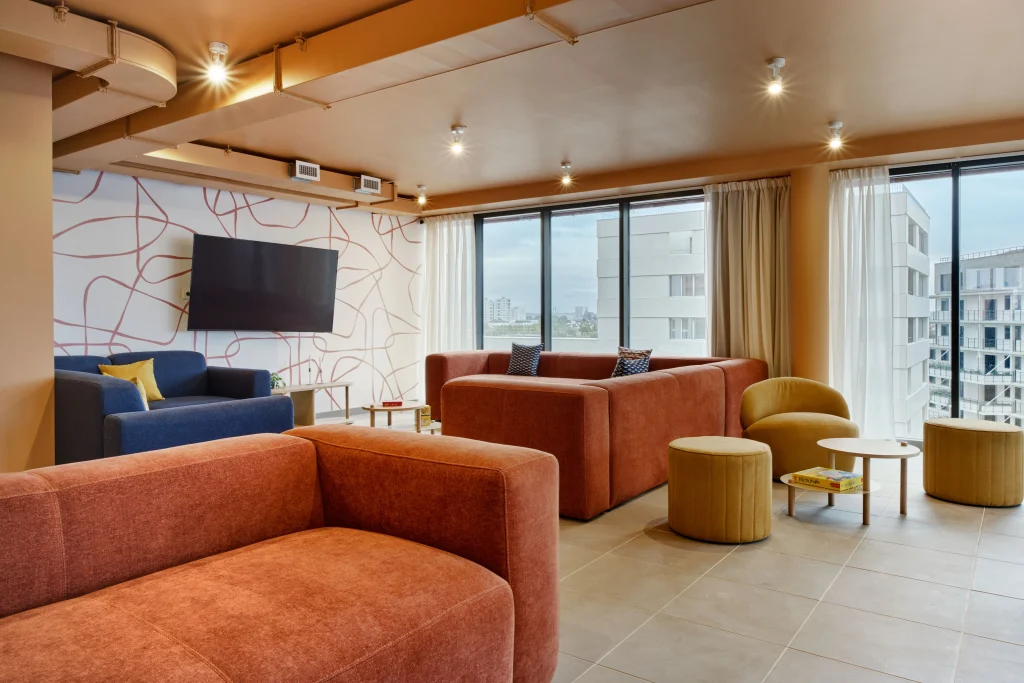 Salón compartido con sofás, televisión y grandes ventanales en Urban Campus Confluences, Ivry-sur-Seine